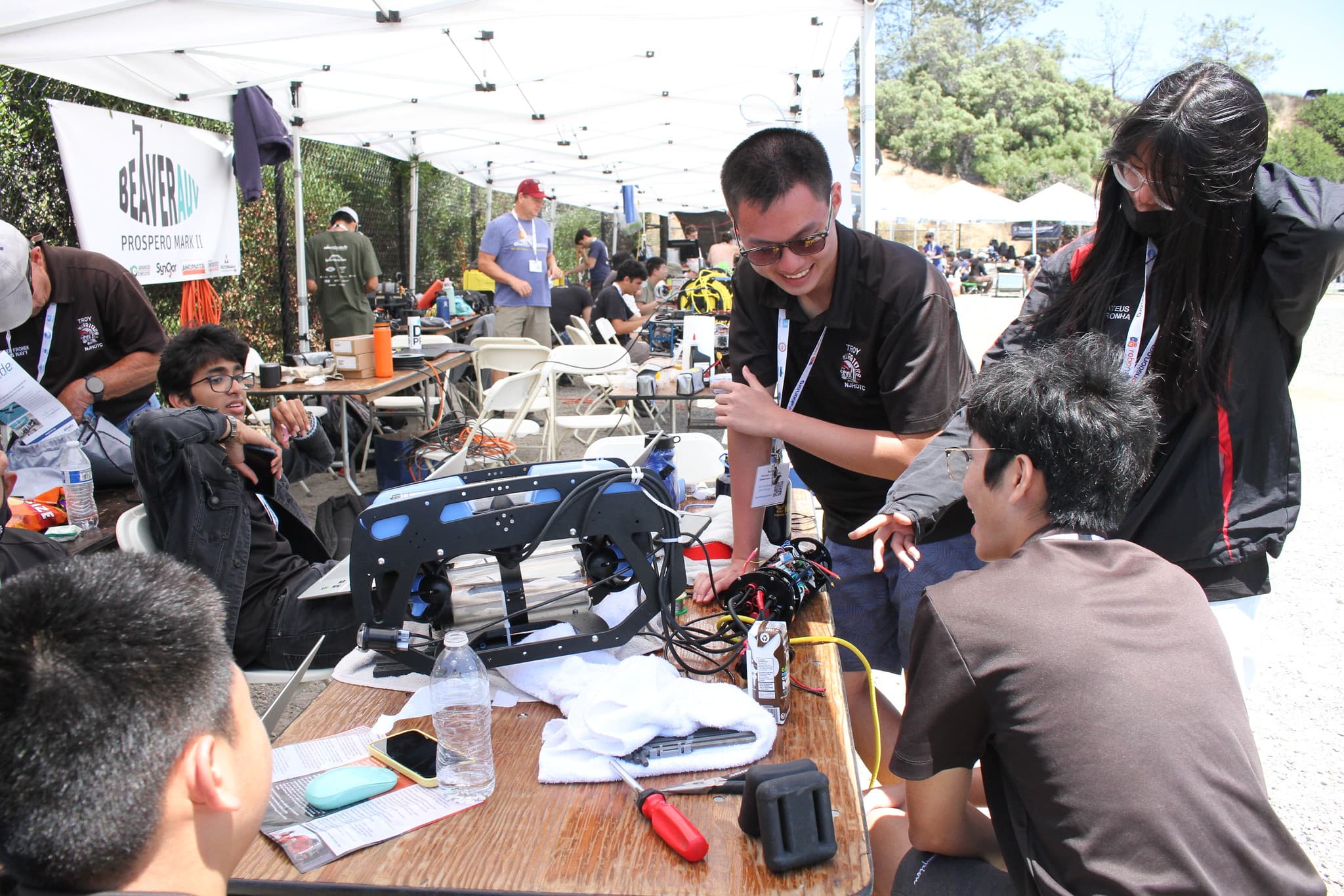 Team gathered around vehicle at competition tent