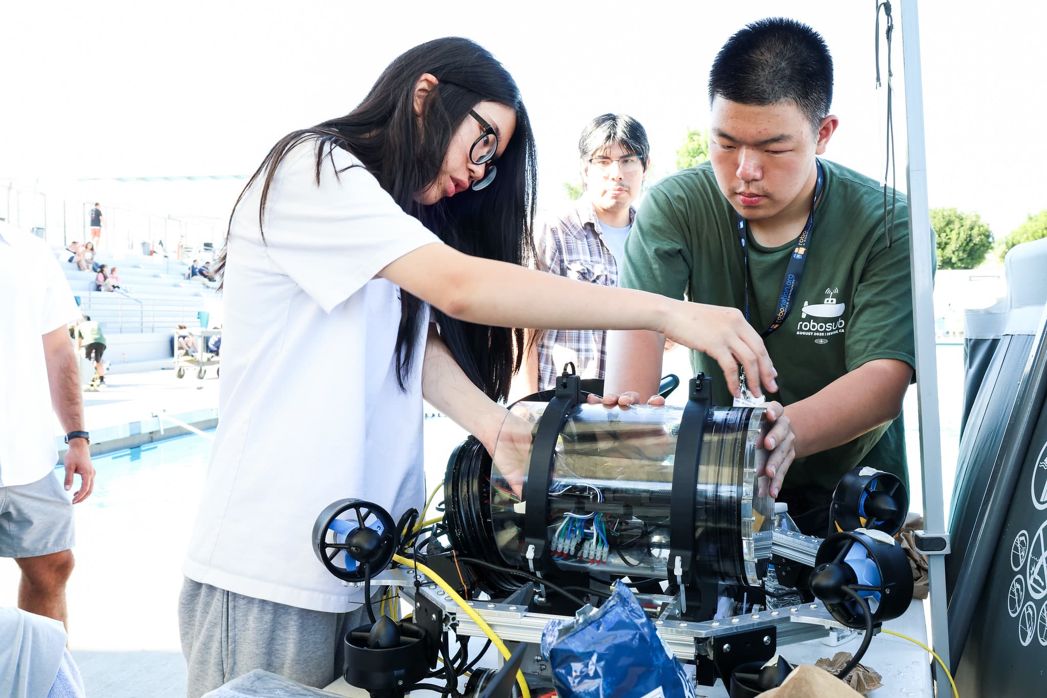 Team members assembling AUV poolside at competition